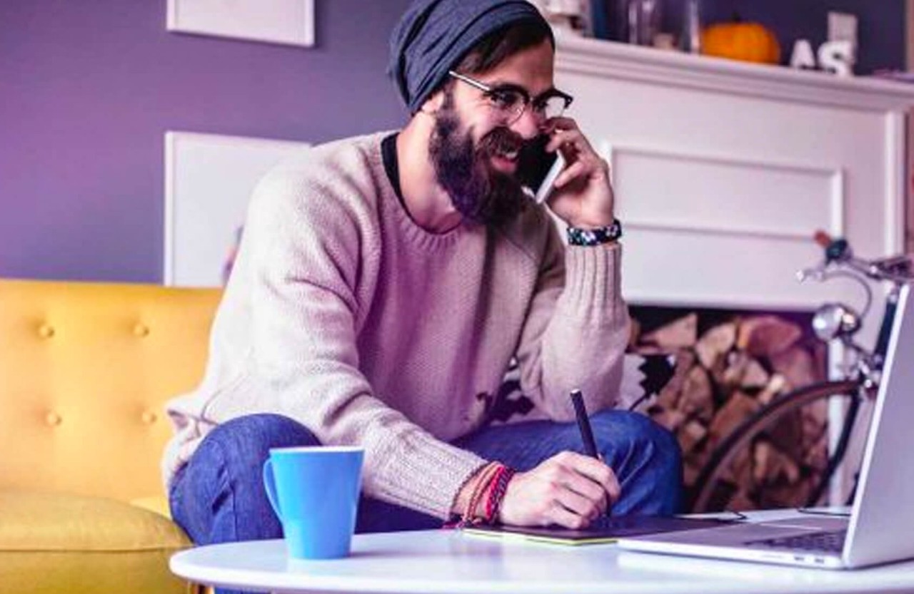 A man in living room taking a phone call