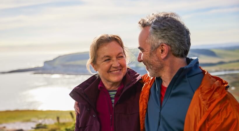 Image of two people standing next to open water